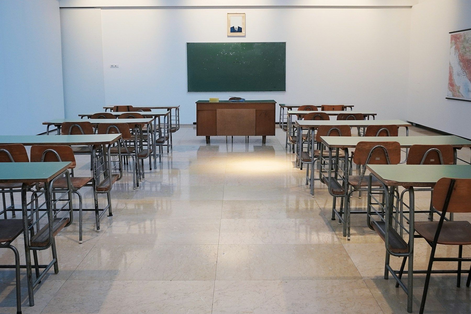 Sala de aula vazia com carteiras enfileiradas e quadro-negro ao fundo