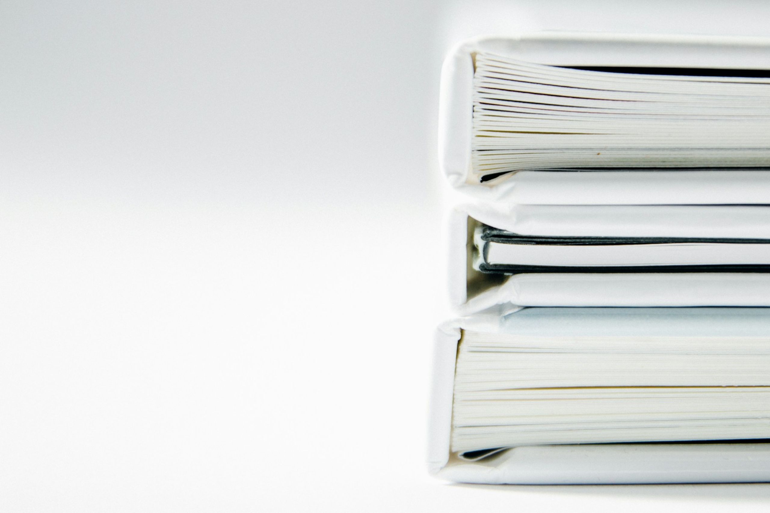 Pilha de pastas de documentos contábeis e fiscais sobre superfície clara