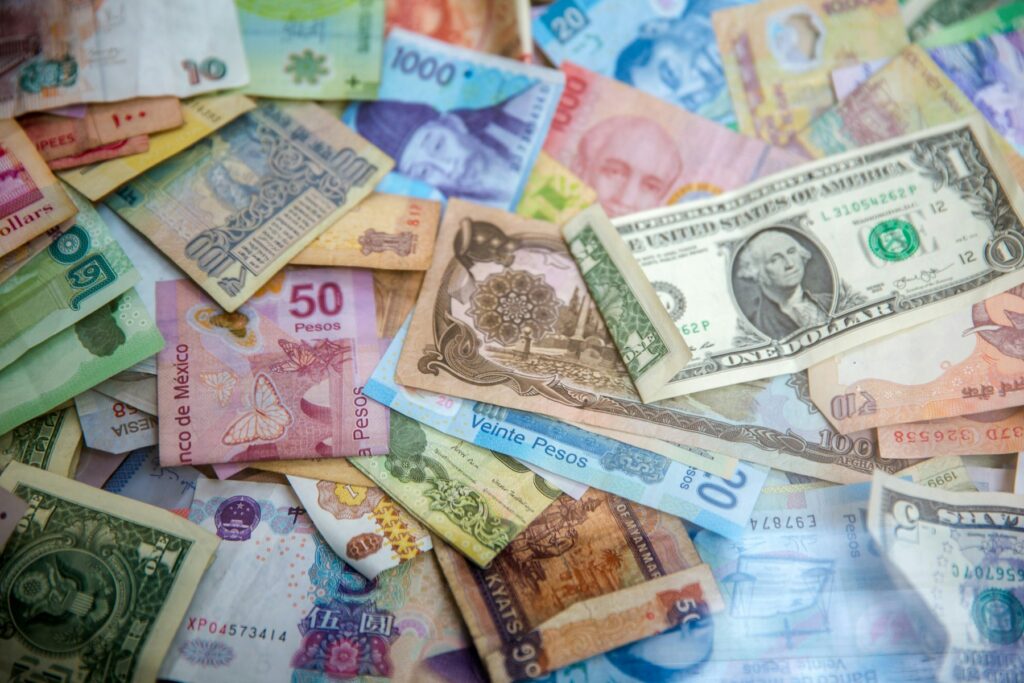 Cédulas de diferentes moedas internacionais espalhadas sobre uma superfície