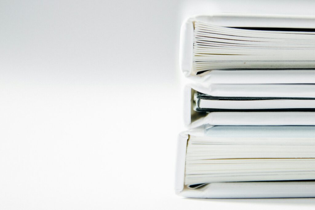 Pilha de pastas de documentos contábeis e fiscais sobre superfície clara